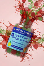 Olivia + Eve Apple Cider Vinegar Gummies bottle with colorful splashes on a pink background