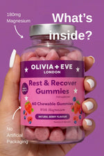 Hand holding a bottle of Olivia + Eve Rest & Recover Gummies with a purple background