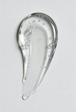 Clear gel or serum with bubbles on a light gray background